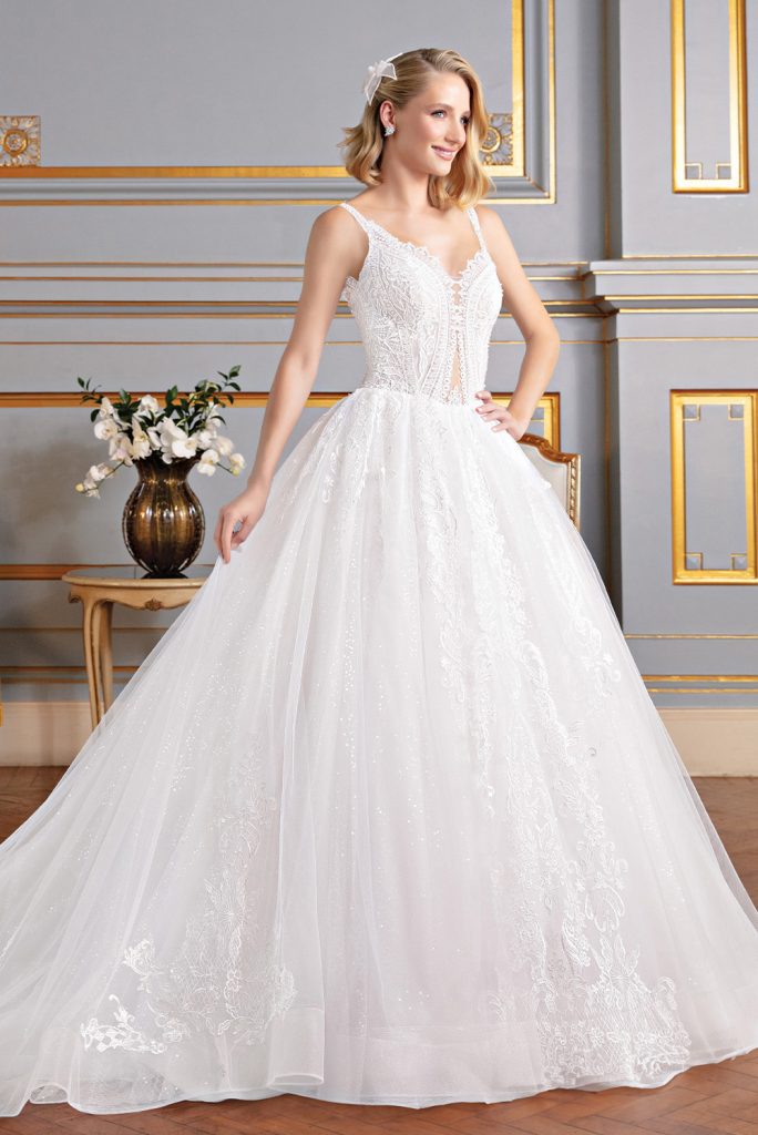 Vestido rodado (Branco), decote V. Saia em organza sobreposta por tule paetezado, camada de tule liso com aplicações de renda fio de seda e barrado de crinol. Corpo transparente com aplicações de renda fio de seda, bordado por madrepérolas, pérolas e miçangas. Costas em decote V com trançado.